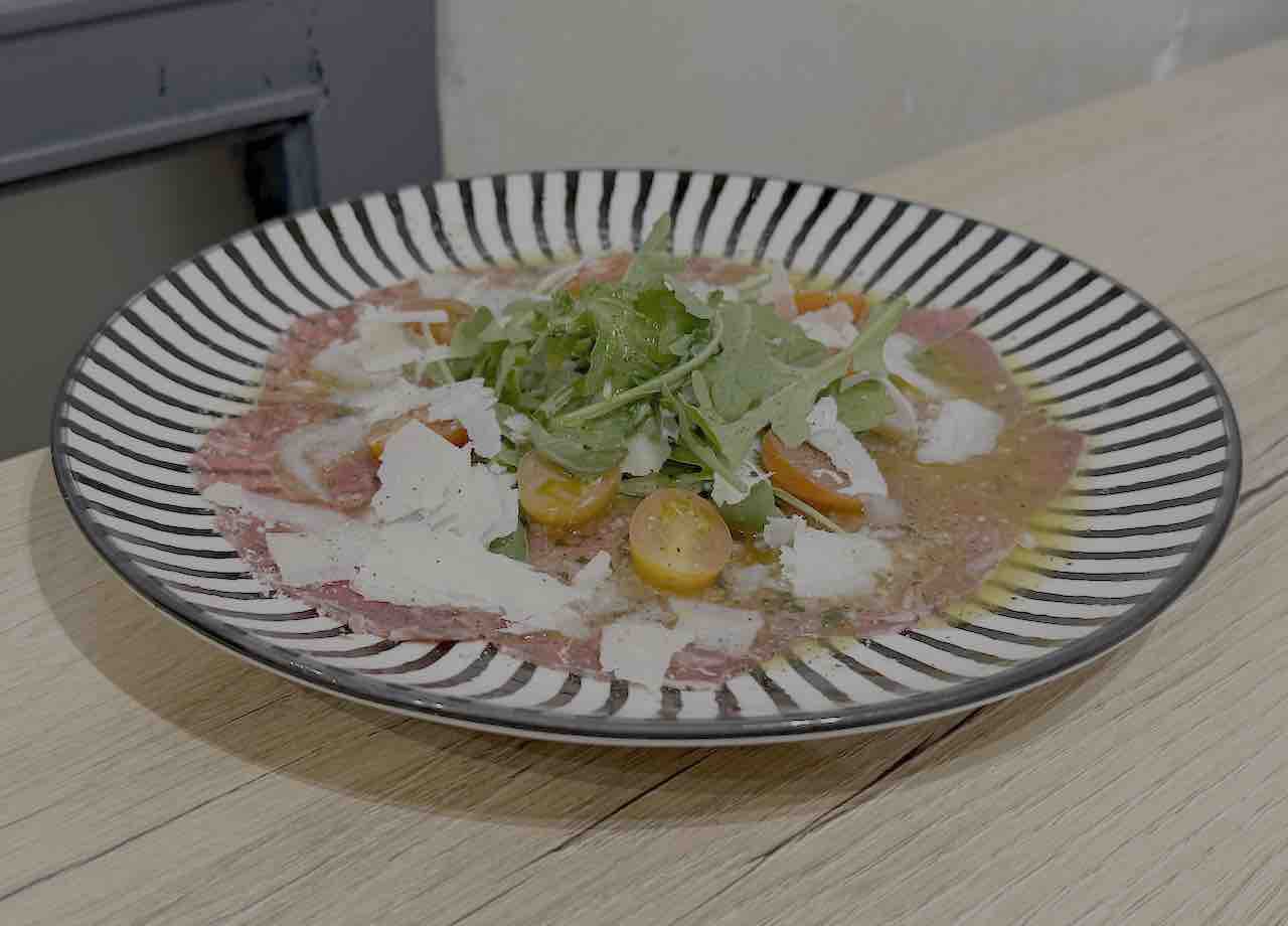Carpaccio de ternera con rúcula, tomatitos y Parmesano del restaurante Marcello, en la calle Floranes de Santander, referente de cocina italiana clásica en Cantabria