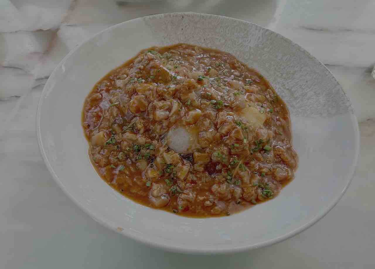 Bacalao confitado con manitas de cerdo en salsa vizcaína