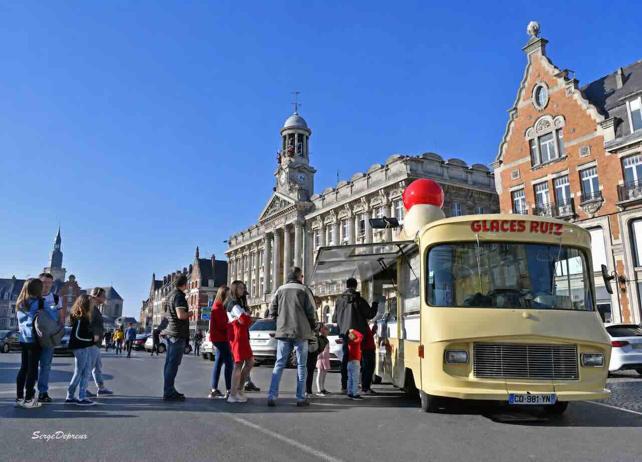 Vehículo de helados Glaces Ruiz atendiendo a clientes en una plaza francesa