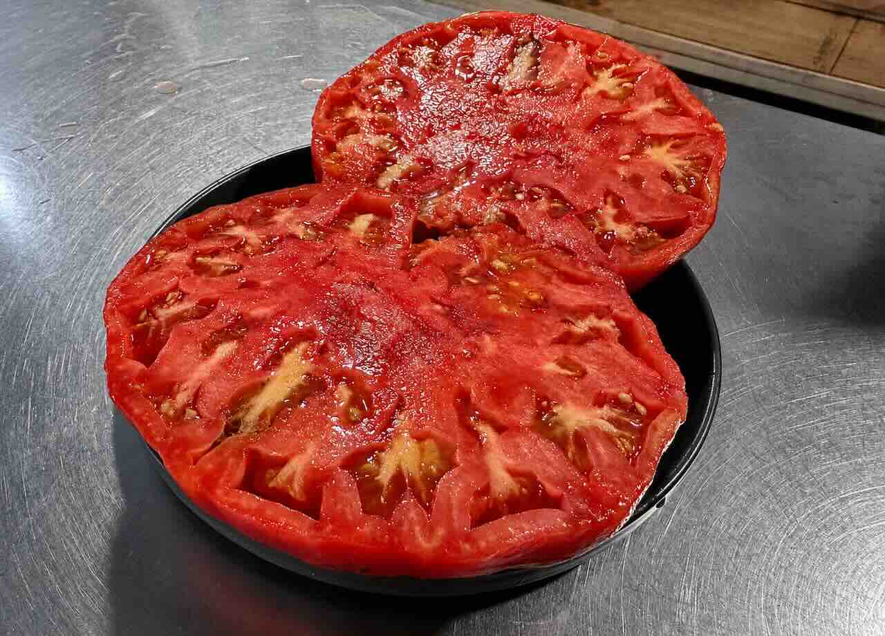 Tomate de Cantabria cortado por la mitad mostrando su pulpa, semillas y jugosidad