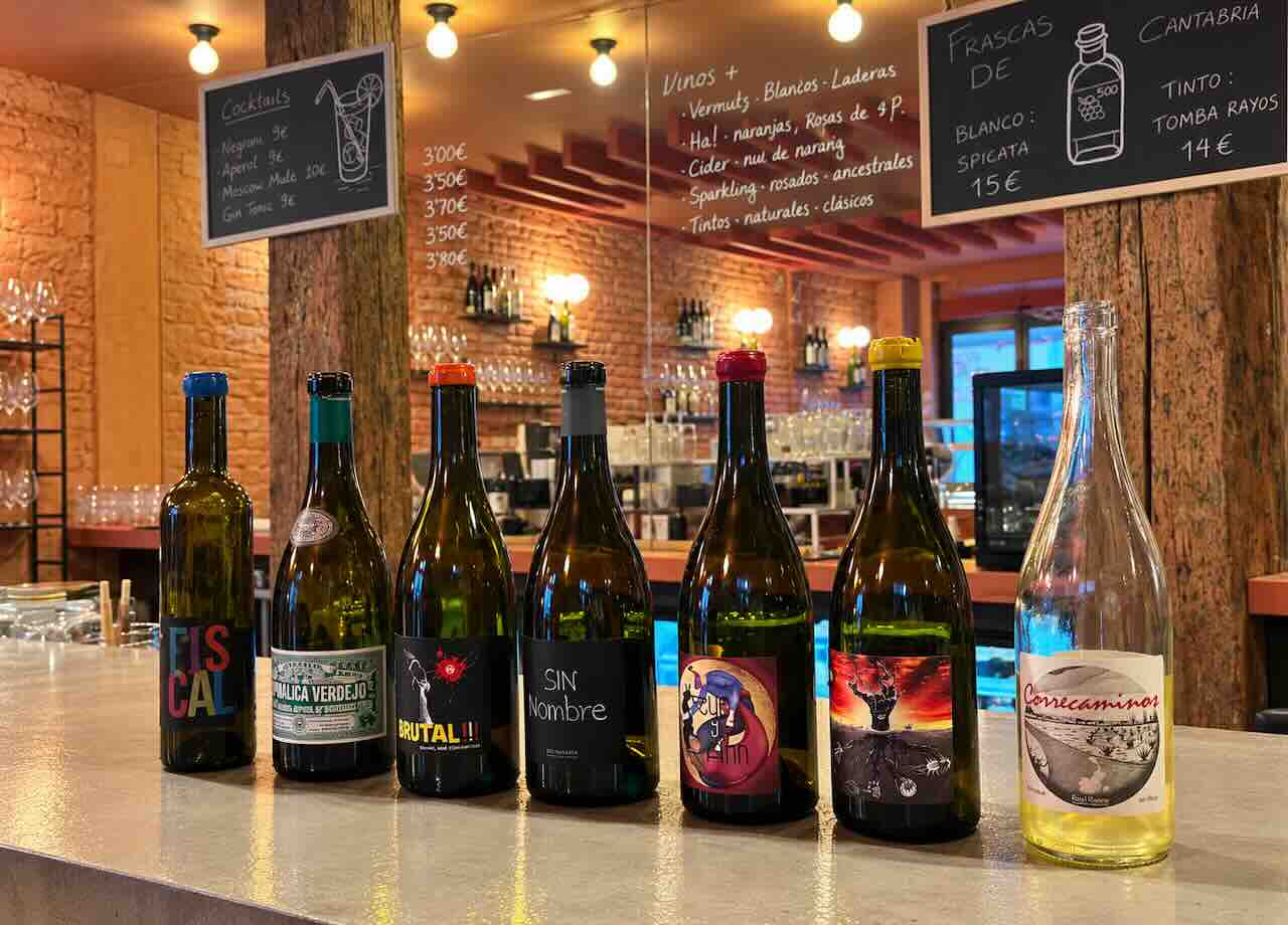 Interior de La Bena Bar de Vinos en Santander con una selección de vinos naturales sobre la barra<br />
