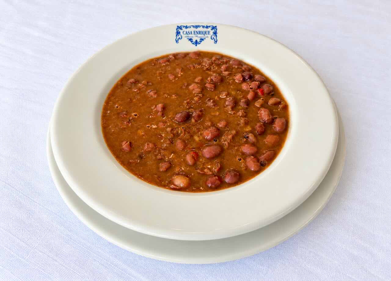 Caricos montañeses servidos en un plato blanco con el logotipo de Casa Enrique, en Solares.